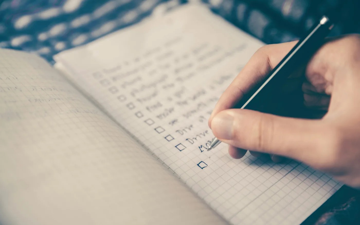 Pessoa organizando uma lista em um caderno